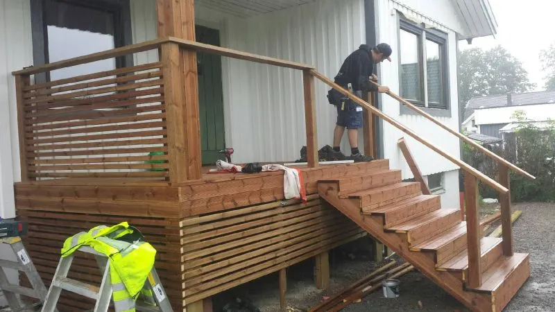 Ny trätrappa och trall vid en entré